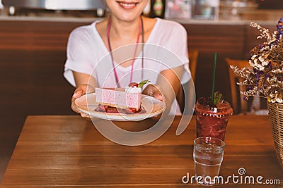 Woman holding plate of slice currant mousse cake in cafe. Stock Photo