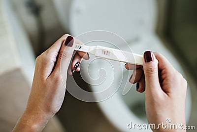 Woman holding a positive pregnancy test Stock Photo