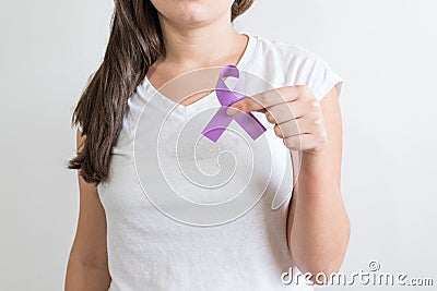 Woman holding a purple ribbon of the International Day for the Elimination of Violence Against Women Stock Photo