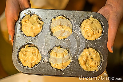 Woman holding raw muffins in muffin form. Stock Photo