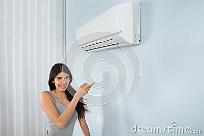 Woman holding remote control air conditioner Stock Photo