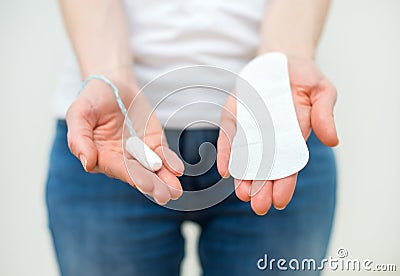 Woman holding sanitary napkin and tampon. Stock Photo