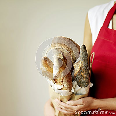 Woman holding a selection of fresh Italian rustic bread, one with poppy seeds Stock Photo