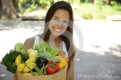 Woman holding shopping paper bag with organic or bio vegetables and fruits. Stock Photo