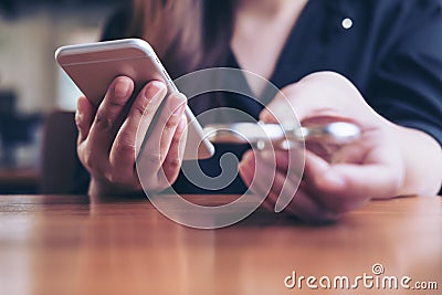 A woman holding smart phone while playing fidget spinner Stock Photo