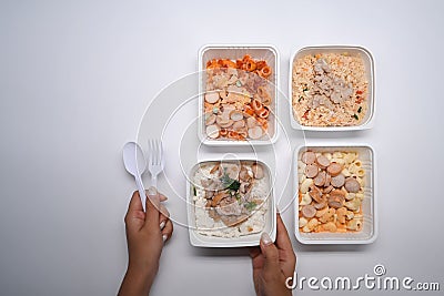 Woman holding spoon and fork ready to microwave and eat several frozen meal. Stock Photo