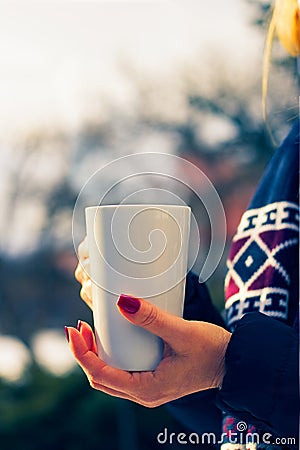 Woman holding a steaming hot mug of coffee Stock Photo