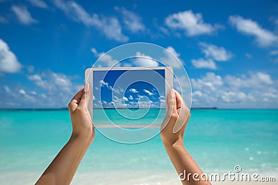 Woman holding tablet computer with screen on the tropical sea. t Stock Photo