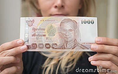 Woman holding 1000 Thai Baht note withdrawn from ATM Stock Photo