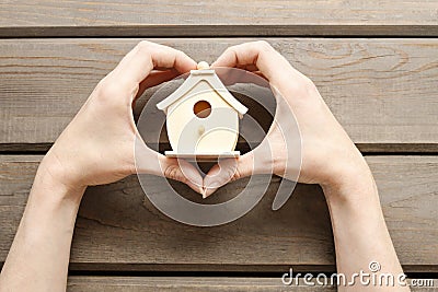 Woman holding tiny wooden house Stock Photo