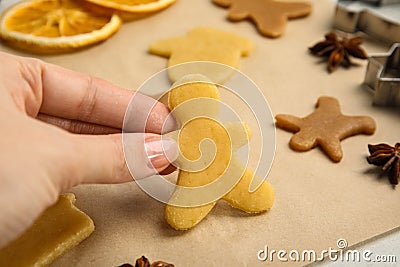 Woman holding uncooked cookie at table, closeup. Christmas biscuits Stock Photo