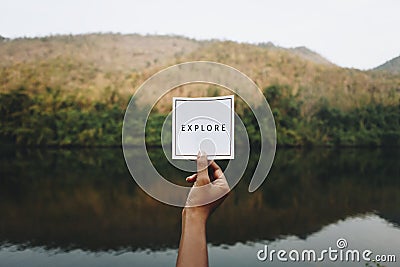 Woman holding up the word explore in nature Stock Photo