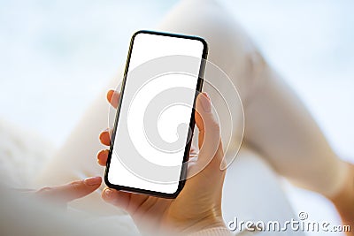 Woman holding and using smartphone at home. Stock Photo