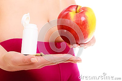 Woman holding vitamins and apple. Health care. Stock Photo