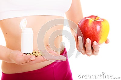 Woman holding vitamins and apple. Health care. Stock Photo