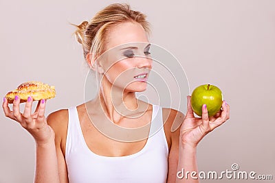 Woman holds cake and fruit in hand choosing Stock Photo