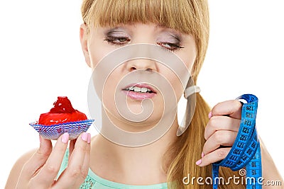 Woman holds cupcake trying to resist temptation Stock Photo