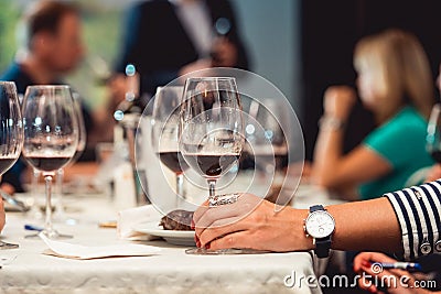 Woman holds glass of red wine. people consider the color of the wine and try how it smells in different glasses Stock Photo