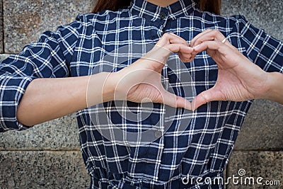 Woman holds heart shape on own Stock Photo