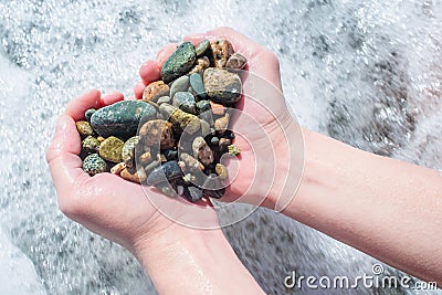 Woman holds a heart from the stones in his hands Stock Photo