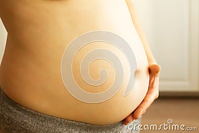 A woman holds her belly. Stock Photo