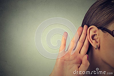 Woman holds her hand near ear and listens carefully Stock Photo