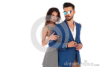 Woman holds man`s arms from behind while he buttons suit Stock Photo