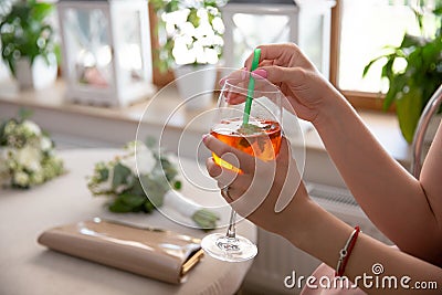 Woman holds orange punsh fresh Cocktail in bar Stock Photo