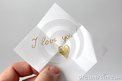 A woman holds a paper message with the text I love you Stock Photo