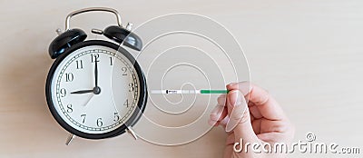Woman holds a positive pregnancy test and alarm clock. Nine months of pregnancy. The concept of the biological clock of Stock Photo