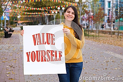 A woman holds a poster with a sign on white Value yourself Stock Photo