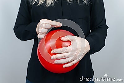 Conceptual photography. The woman holds a red ball near his belly, which symbolizes bloating and flatulence. Then she brings a nee Stock Photo