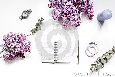 Woman home office with lilic flowers, notebook white desk background top view mock up Stock Photo