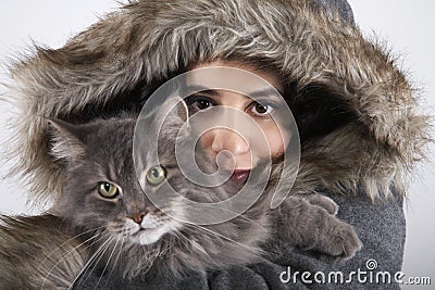 Woman In Hooded Fur Coat Holding Cat Stock Photo