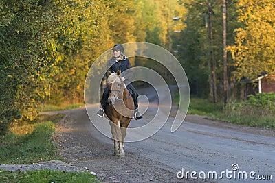 Woman horseback riding in sunset Stock Photo