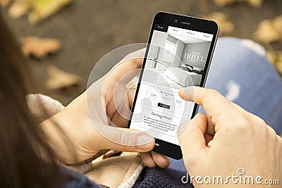 woman with hotel website design phone in the park Stock Photo