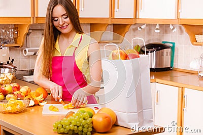 Woman housewife in kitchen cutting orange fruits Stock Photo