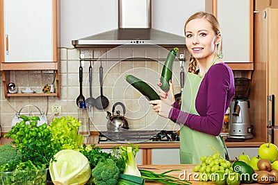 Woman housewife in kitchen with green vegetables Stock Photo