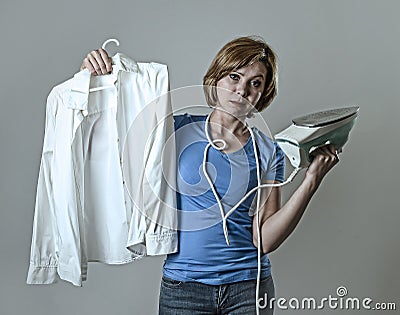 Woman or housewife sad bored and stressed holding white shirt and iron angry and frustrated Stock Photo