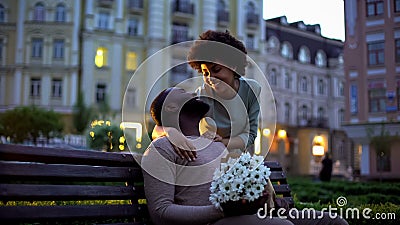 Woman hugging boyfriend, looking with love, holding flowers, romantic date Stock Photo