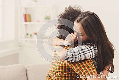 Woman hugging her depressed friend at home Stock Photo