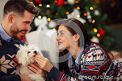 Woman with husband at home with cute dog celebrating Christmas e Stock Photo