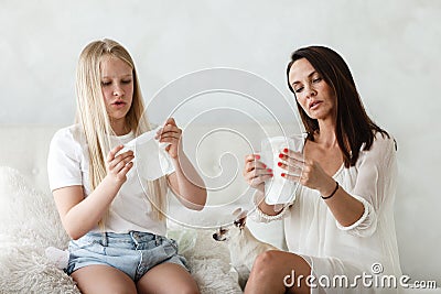 Woman hygene concept. Periods. Menstrual cycle. Mother explains daughter how to use hygiene pads and tampons. Woman and Stock Photo