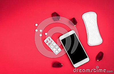 Woman hygiene protection or sanitary pads with rose petals and mobile phone on red background. Menstrual cycle tracking Stock Photo