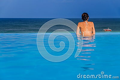 Woman in the infinity pool Stock Photo