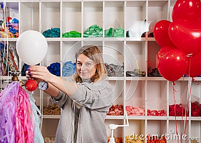 a woman inflates of helium from a white balloon. Stock Photo