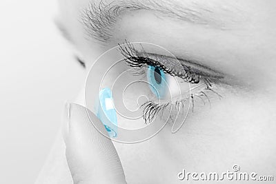 Woman inserting a contact lens in eye. Stock Photo