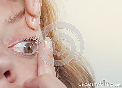 Woman inserts a contact lens into the eye. Close-up, domestic scene. Optics, Vision, Optical Instruments Stock Photo