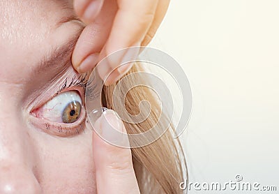 Woman inserts a contact lens into the eye Stock Photo
