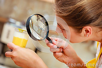 Woman inspecting food with magnifying glass. Stock Photo